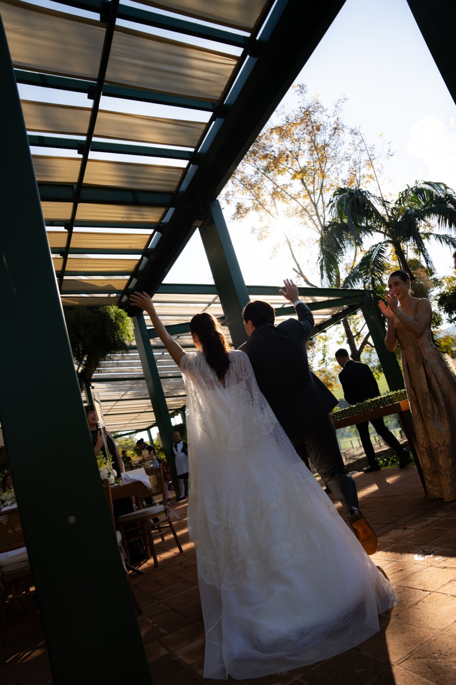 Noivos de mãos dadas entrando na festa, still em preto e branco
